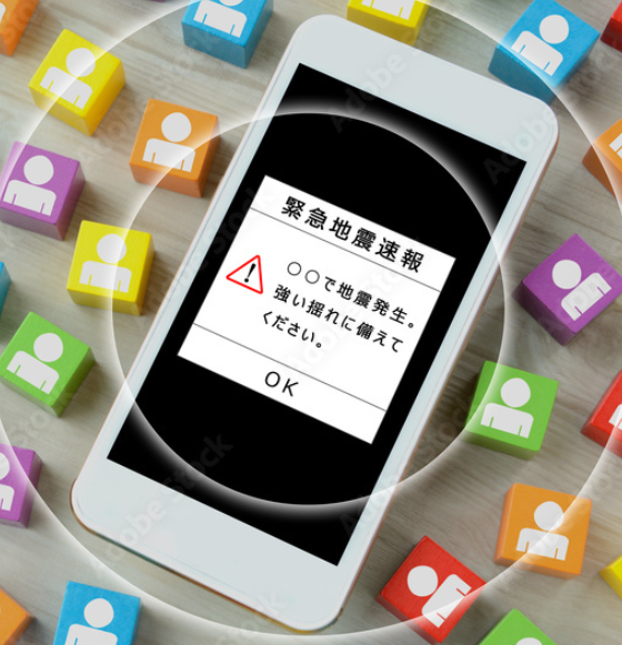 Smartphone shows an emergency earthquake alert with a red warning triangle and OK button; surrounded by colorful blocks with user icons.